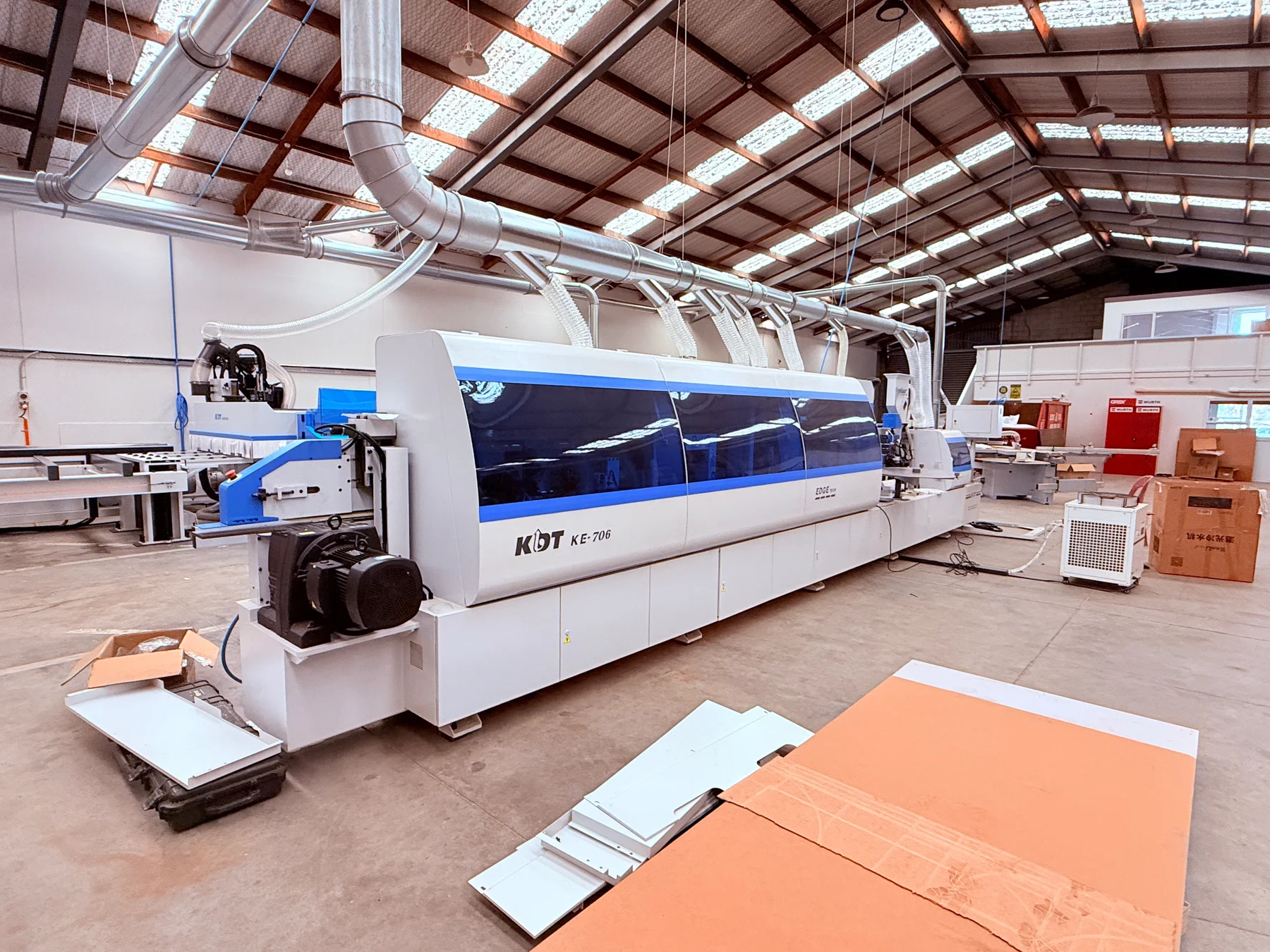A blue and white KDT machine on the Reliable Kitchen workshop floor.