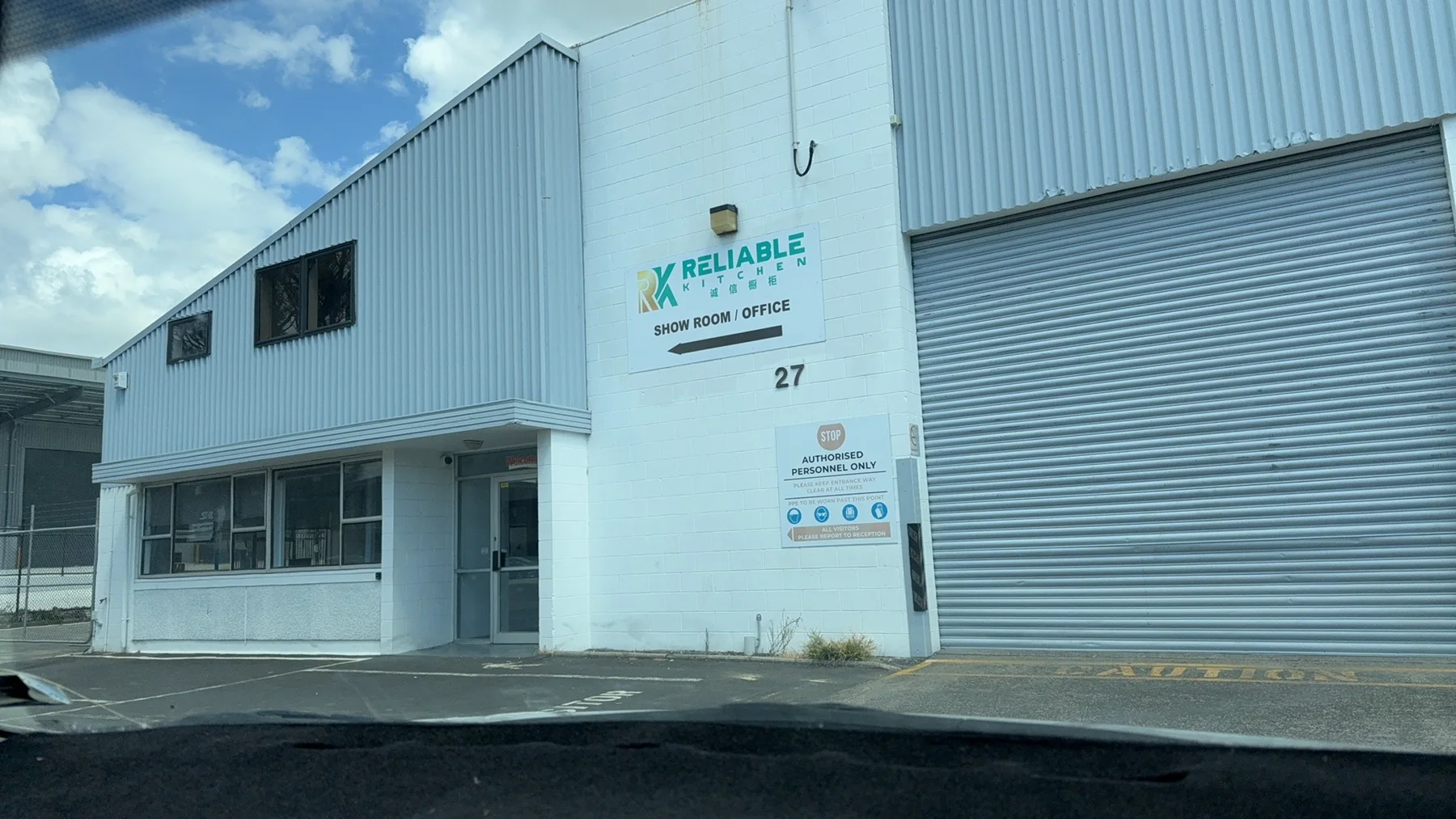 The Reliable Kitchen factory exterior with its business sign, office entrance and roller door.